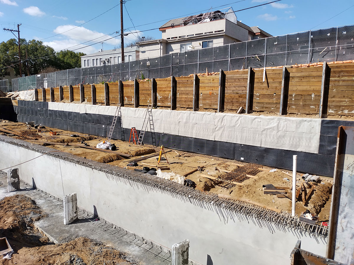 Pour-in-place retaining wall construction
